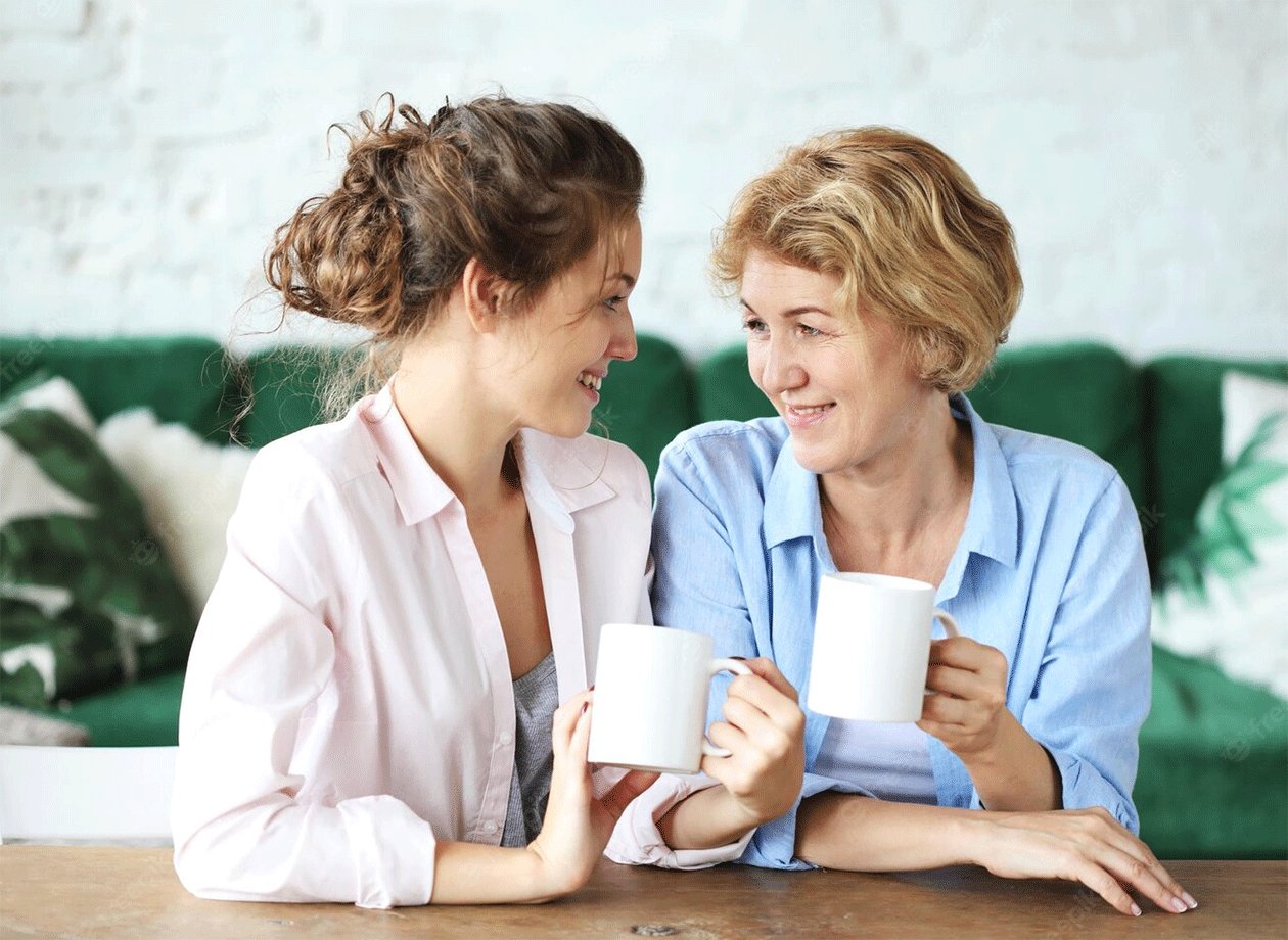 Two generations sharing conversation over a warm drink