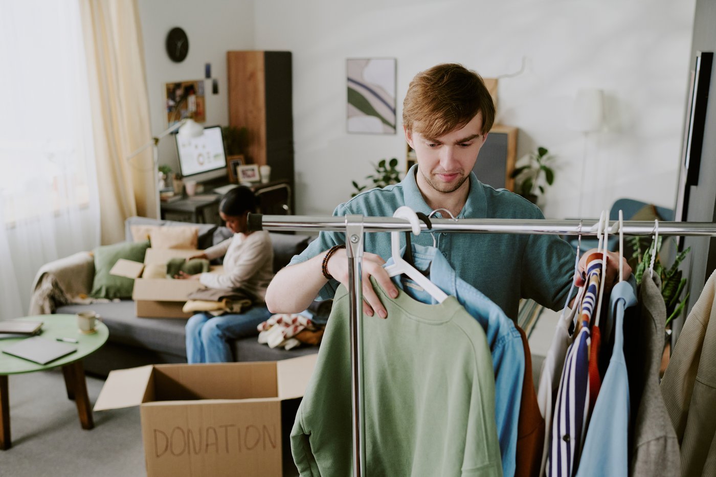 A person organizing clothing and belongings for donation