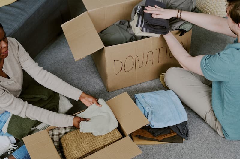 People carefully sorting belongings into donation boxes