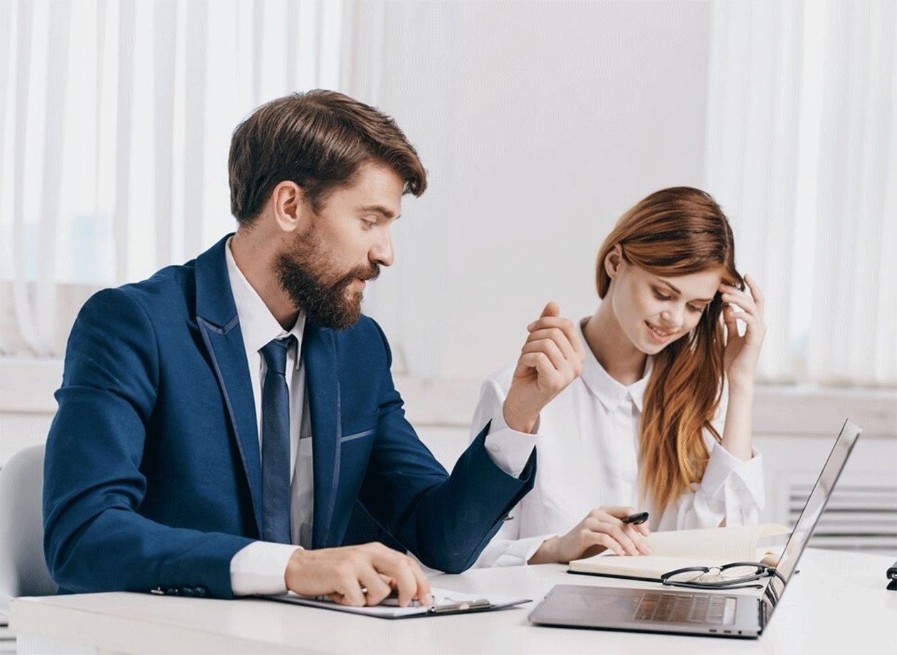 A colleague offering support during a conversation at a laptop